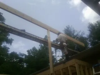 Carpenter setting a ridge beam over a new addition frame — Ice Dam Removal by Roofing Brothers in Huntsville